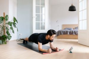 man doing beginner yoga at home with app